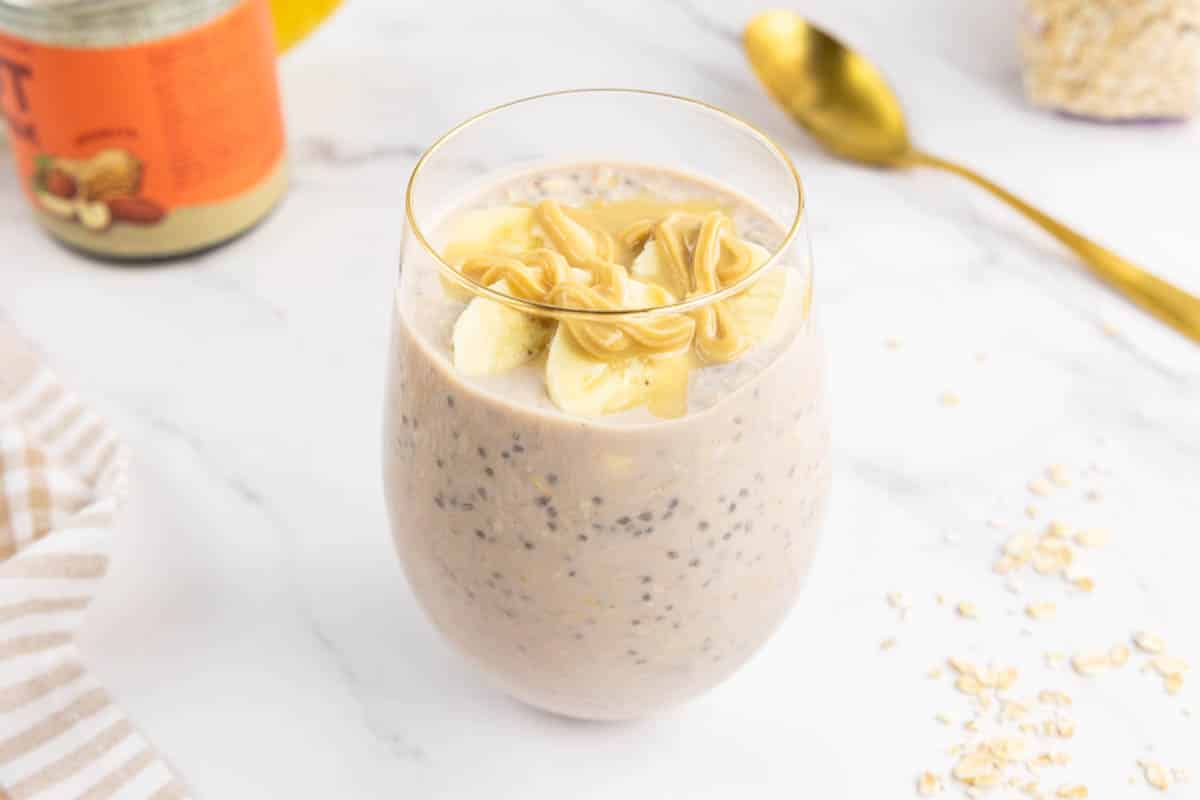 High calorie overnight oats in a glass topped with banana and peanut butter