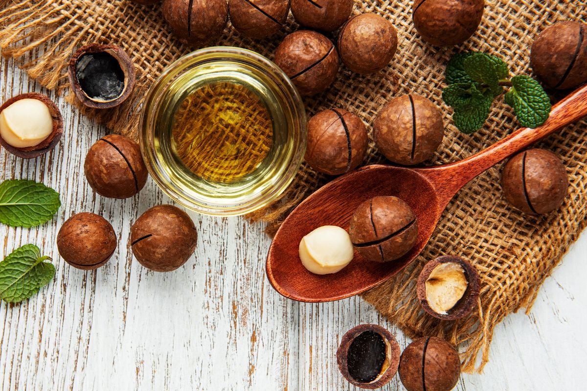 The Top 10 Highest Protein Nuts 11 Whole and shelled macadamia nuts a wooden table.